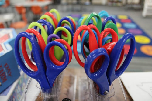 Colored scissors in a scissors rack.