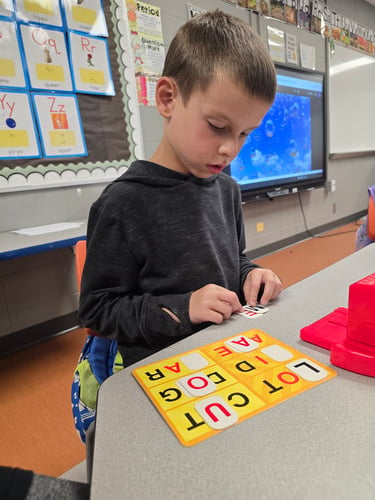 Student playing with letter tiles.